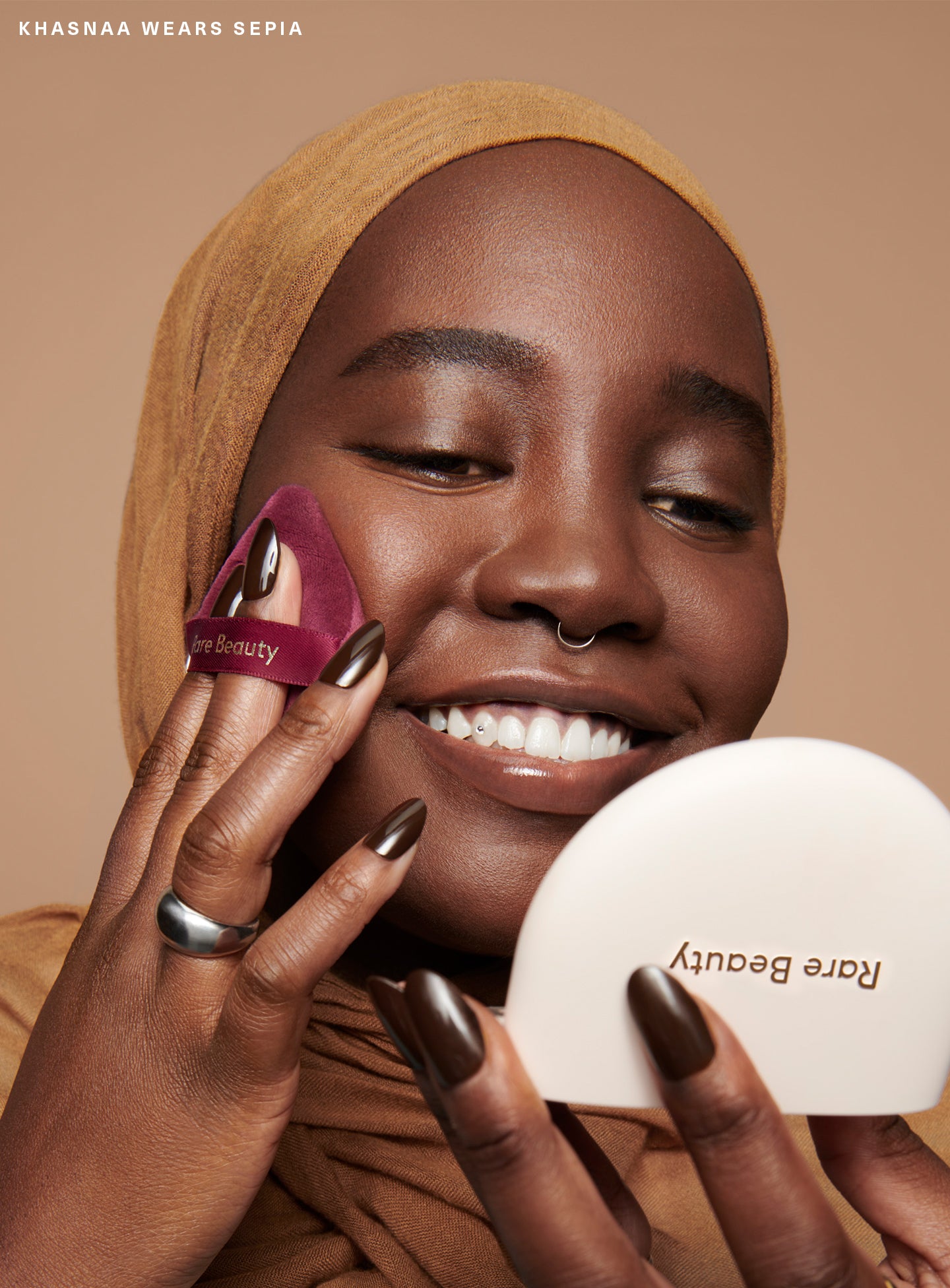 Model Khasnaa applying Rare Beauty's True to Myself Pressed Finishing Powder in the shade Sepia with the Soft Touch Powder Puff.