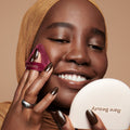 Model Khasnaa applying Rare Beauty's True to Myself Pressed Finishing Powder in the shade Sepia with the Soft Touch Powder Puff.