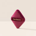 Rare Beauty's Soft Touch Powder Puff, a diamond-shaped velvety powder puff for precise powder application.