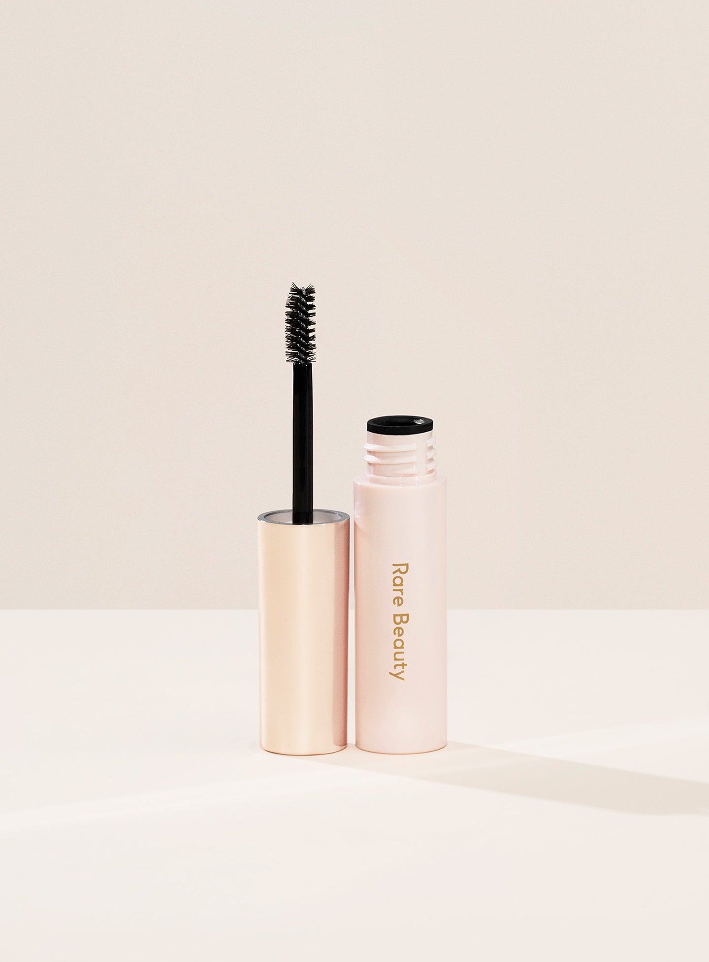 | A tube of Rare Beauty's Brow Harmony Flexible Lifting Gel and its brush.