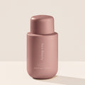 Rare Beauty's Find Comfort Hydrating Body Lotion standing on a white table against a white background.