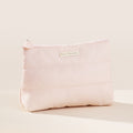 The outside of the Puffy Makeup Bag by Rare Beauty in soft peach.